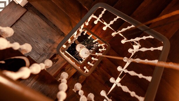 Un escalier en colimaçon avec une rampe en métal et un plancher en bois.