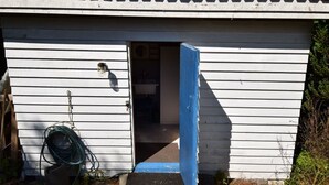 Un petit bâtiment composé d’une seule pièce, avec une porte ouverte vers l’intérieur.