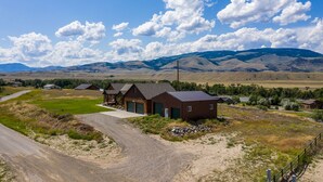 A rural property with a large house, a garage, and a driveway leading to a gravel road. - Yellowstone Trail - Great Home Overlooking the Yellowstone River (Pray)