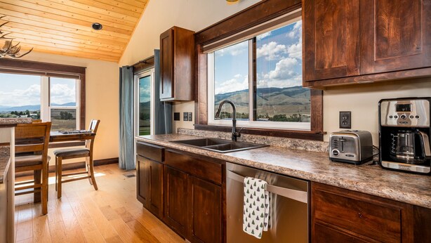 A kitchen with wooden cabinets, a granite countertop, a sink, a toaster, and a coffee maker. - Yellowstone Trail - Great Home Overlooking the Yellowstone River (Pray)
