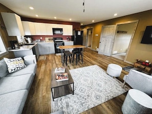 A modern living room with a sofa, a coffee table, and a rug.