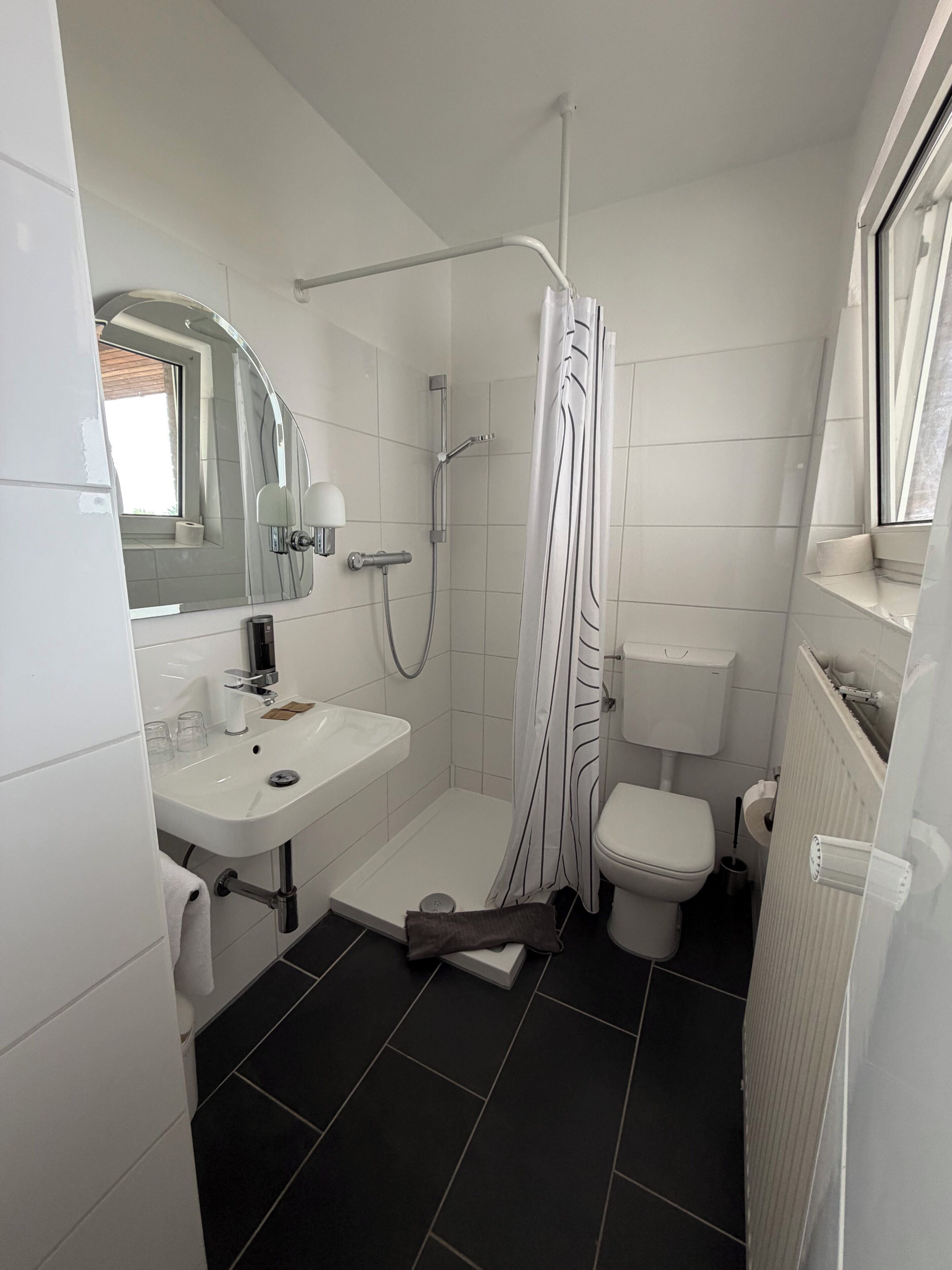 Une petite salle de bain comprenant une douche, des toilettes et un lavabo.