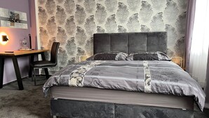 Ein Schlafzimmer mit einem großen Bett, einem Schreibtisch und einem Sessel.