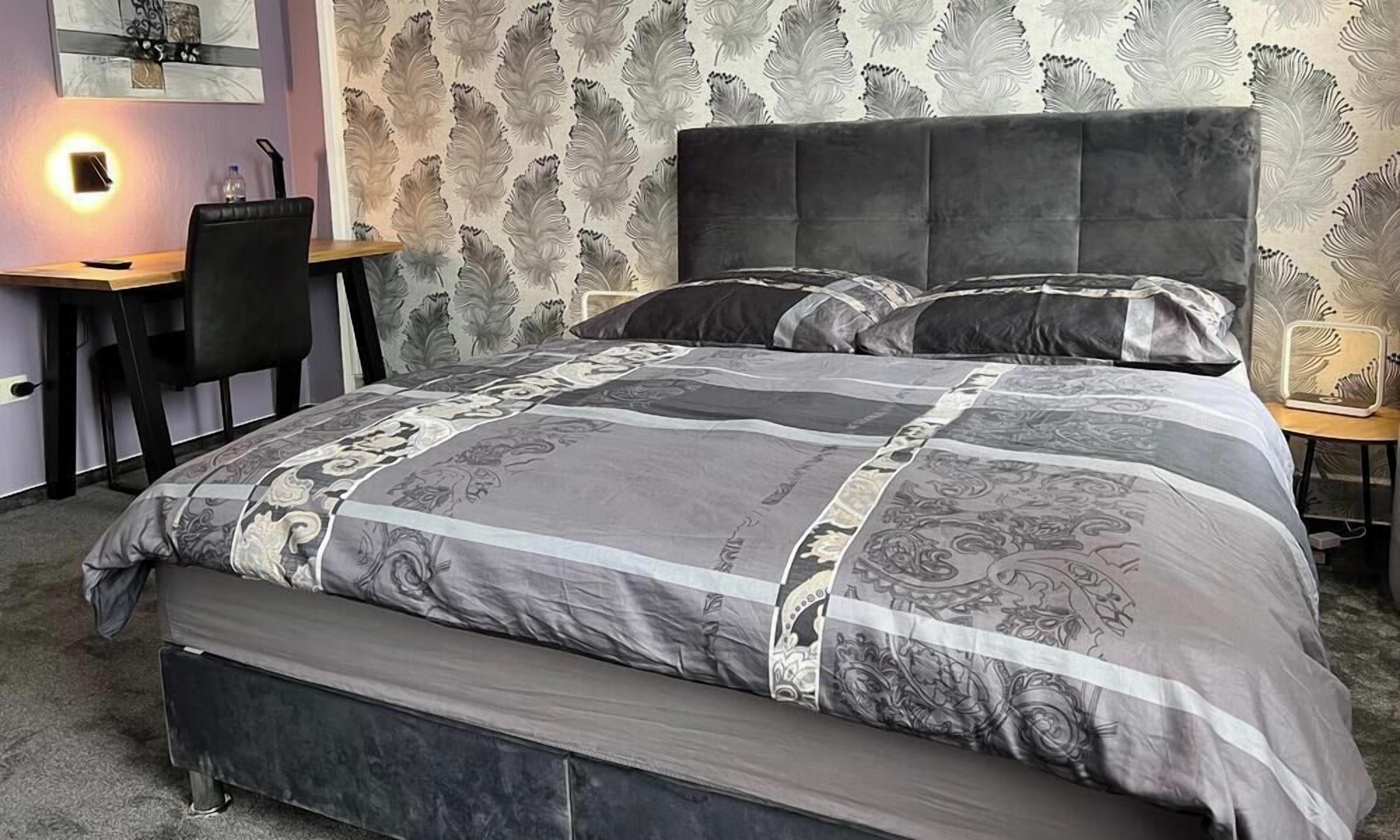 Un dormitorio con cama, escritorio y silla.