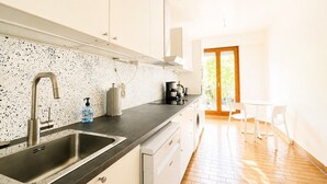 Eine moderne Küche mit Spülbecken aus Edelstahl, einer Kaffeemaschine und einem Wasserspender.