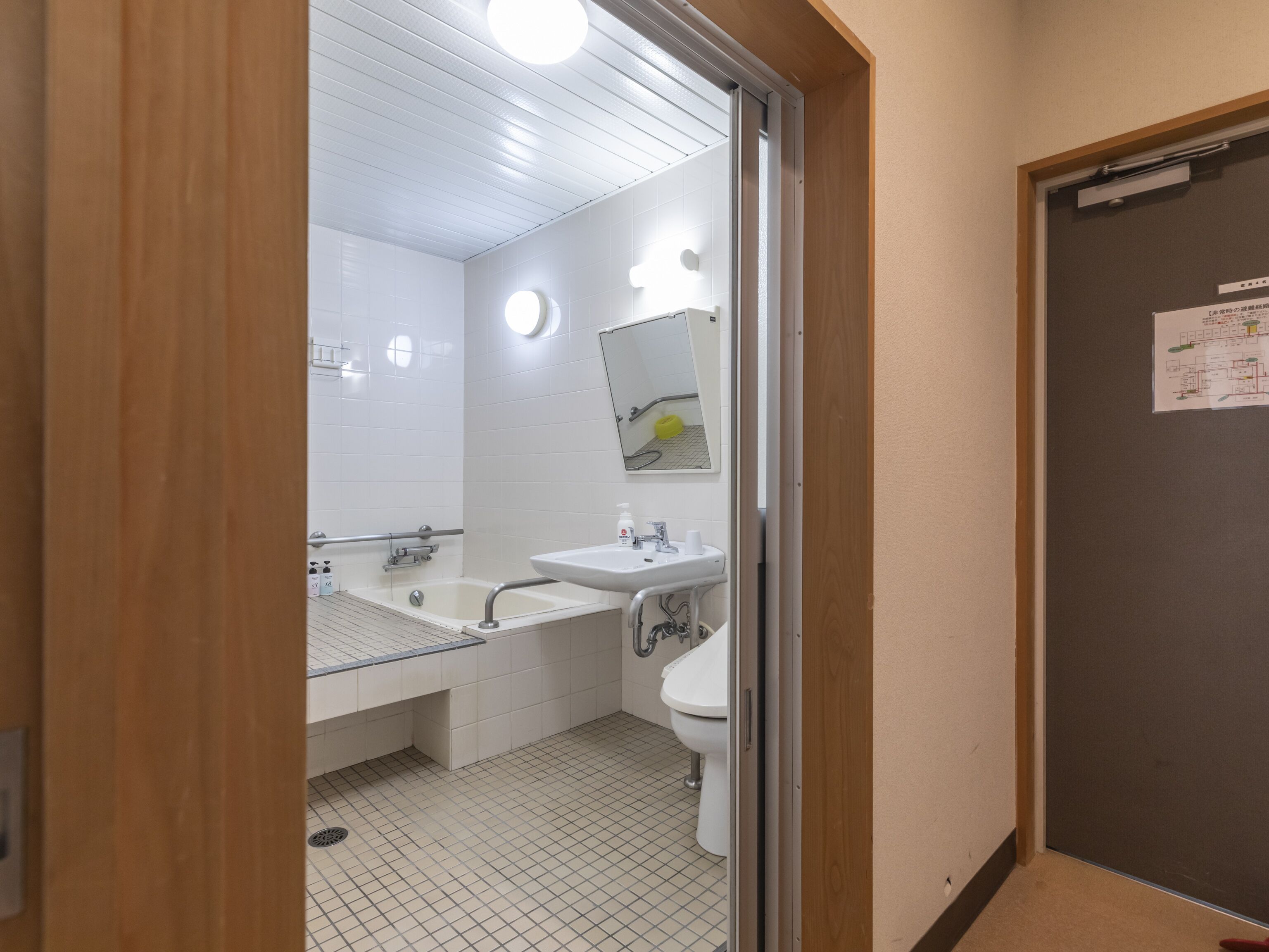 A modern bathroom with a glass partition, a sink, a toilet, and a mirror.