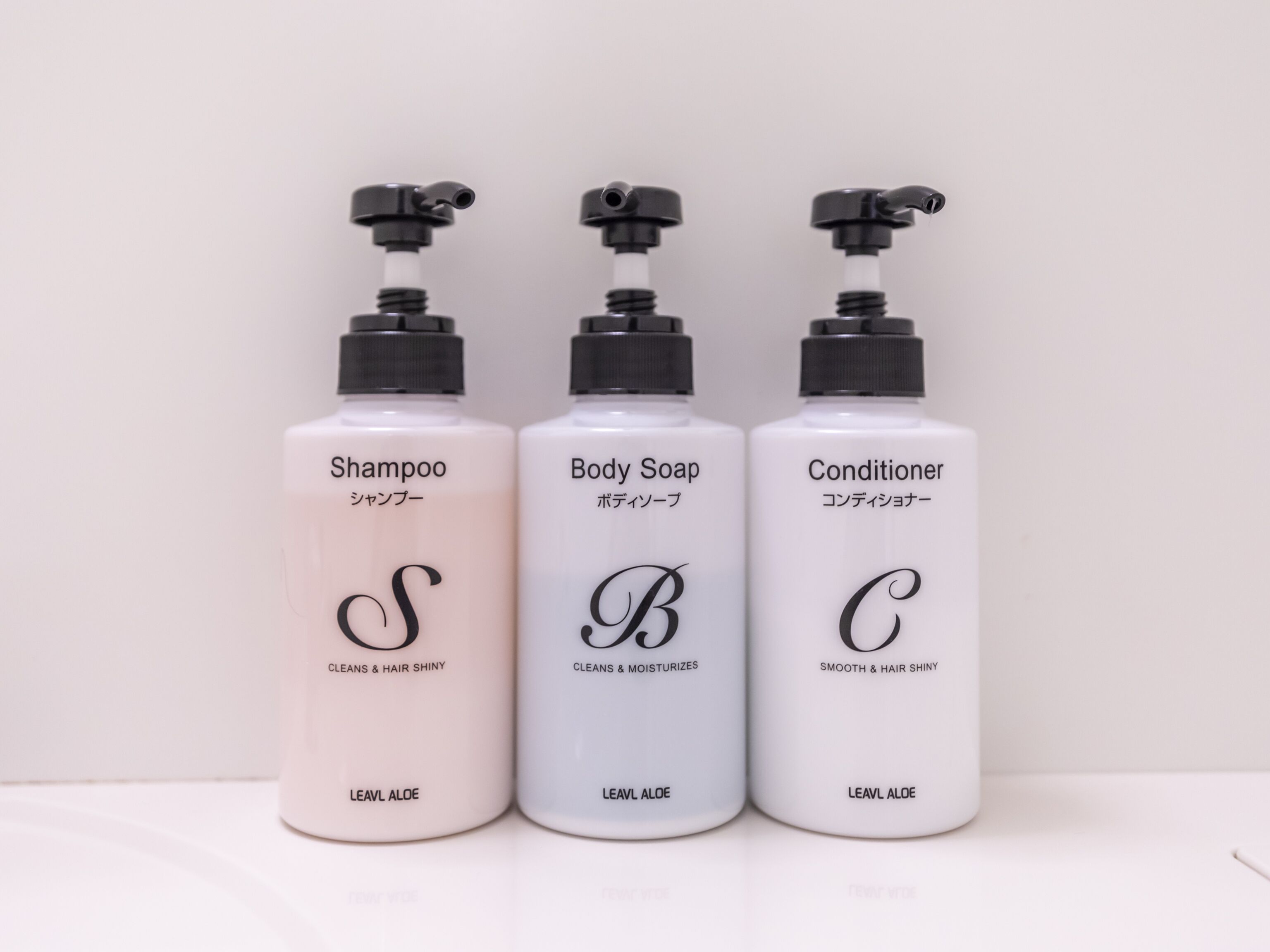 Drie flessen Leavl Aloë shampoo, douchezeep en conditioner.