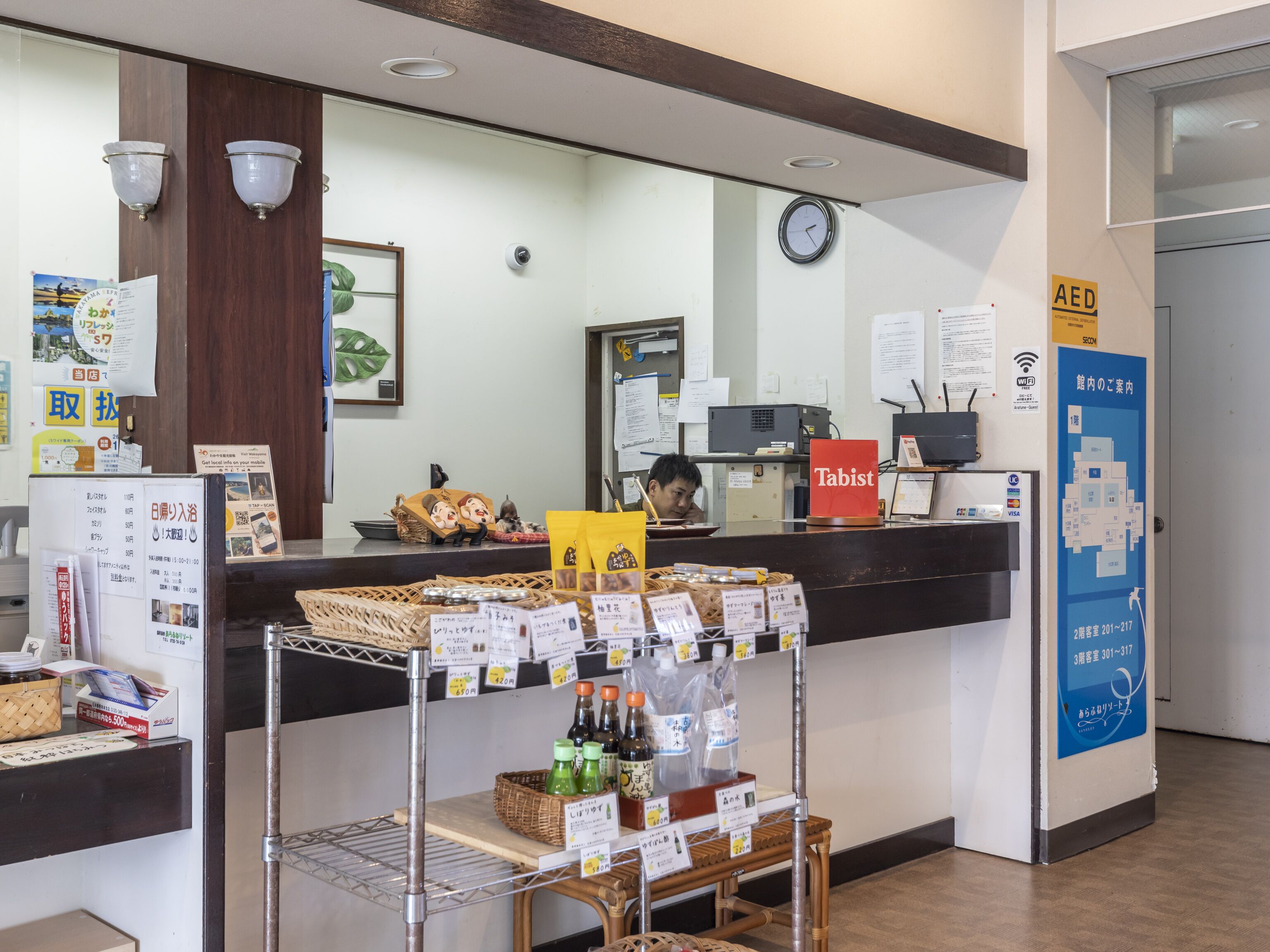 A reception area with a counter, a clock, and various informational posters.