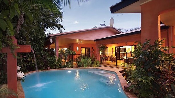 Une maison moderne dotée d’une piscine, le tout entouré d’une végétation luxuriante.