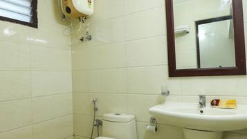 Une salle de bain équipée de toilettes, d’un bidet et d’un lavabo.