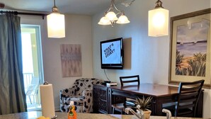 A modern kitchen with granite countertops, stainless steel appliances, and a dining area with a table and chairs. - Clam Shell at Grand Panama - Intimate and Serene Perfect spot for relaxing (Panama City Beach)
