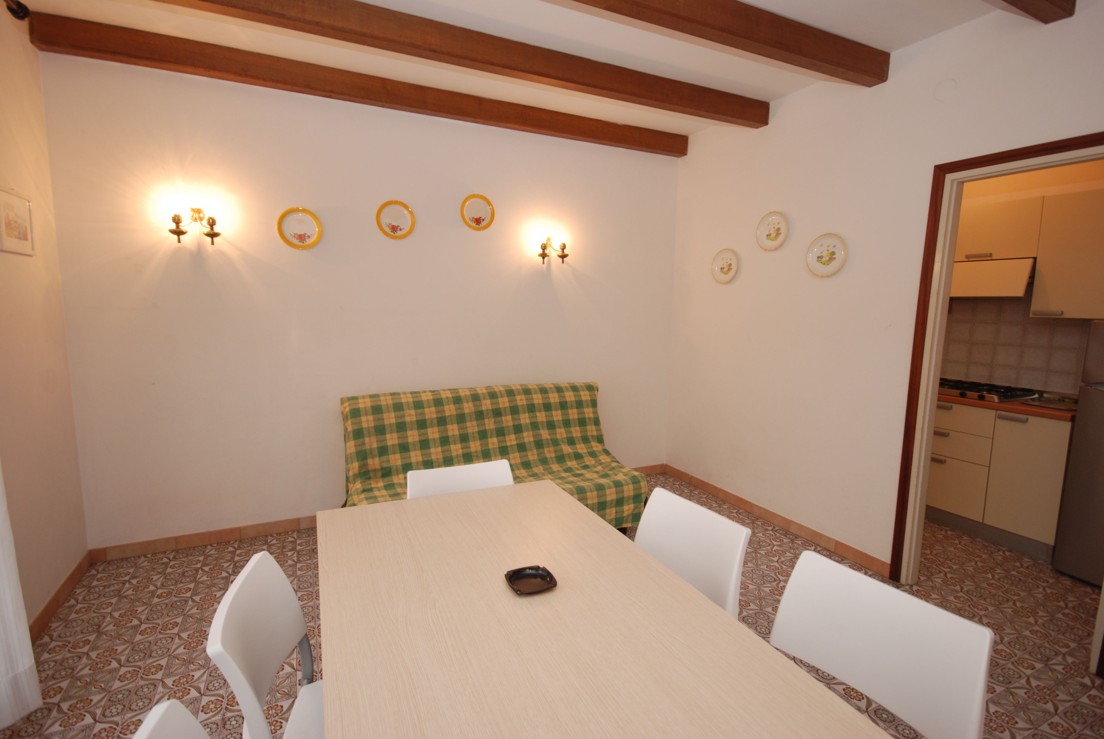 A dining area with a checkered bench, a table, and chairs.