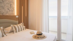 Ein Hotelzimmer mit einem Bett, einem Hut und einem Buch auf dem Bett.