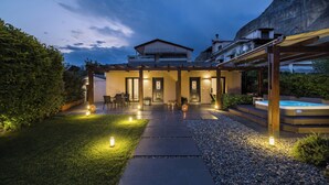 A modern house with a patio, outdoor seating, and a hot tub. - Meteora boutique villa A (Kalampaka)