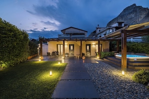 A modern house with a patio, outdoor seating, and a hot tub.