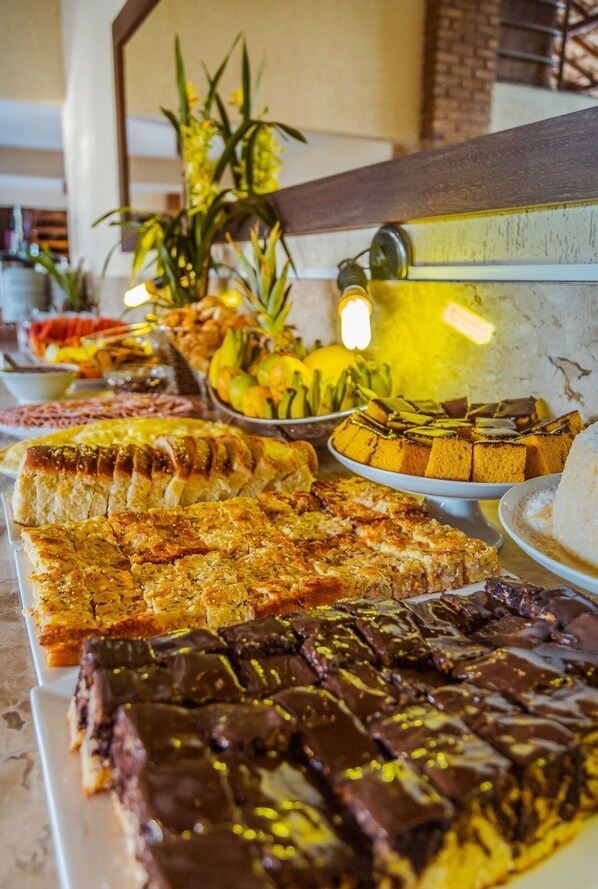 A buffet with various desserts and fruits. - Vila Miola Hotel (Porto Seguro)