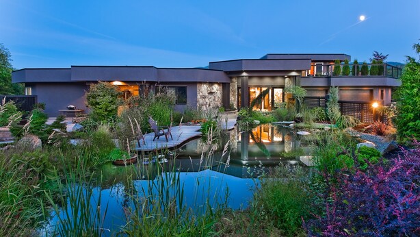 A modern house with a pool, surrounded by lush greenery and a night sky. - The Lagoon Suite at The Estuary Inn (Nanoose Bay)