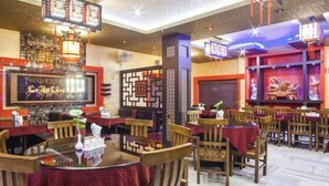 A restaurant with round tables, wooden chairs, and red tablecloths. - Hotel Lee Garden, Near Blue Flag Beach(500 Mtrs), Puri (Puri)