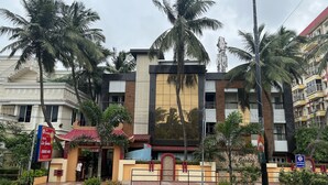 A hotel with a modern facade, palm trees, and a signboard for the hotel. - Hotel Lee Garden, Near Blue Flag Beach(500 Mtrs), Puri (Puri)