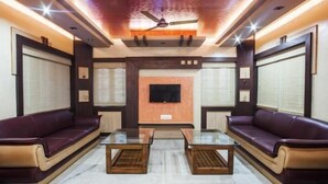 A modern living room with two leather sofas, a glass coffee table, and a ceiling fan. - Hotel Lee Garden, Near Blue Flag Beach(500 Mtrs), Puri (Puri)