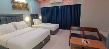 A hotel room with two beds, a desk, and a chair.