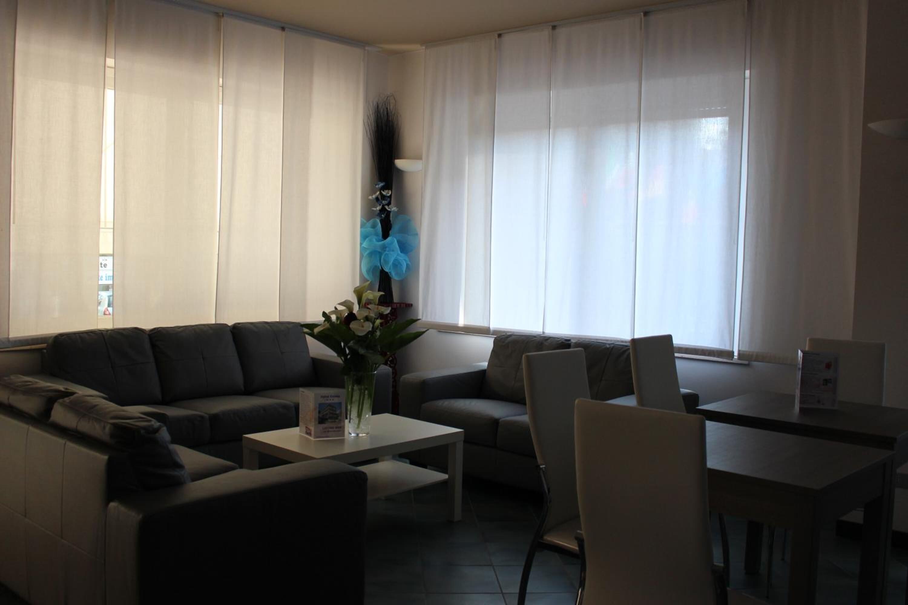 A living room with a sofa, a coffee table, and a dining table with chairs.