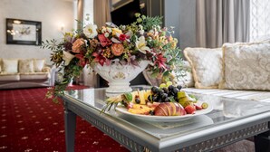 Une table à manger avec un plateau de fruits et un arrangement floral.