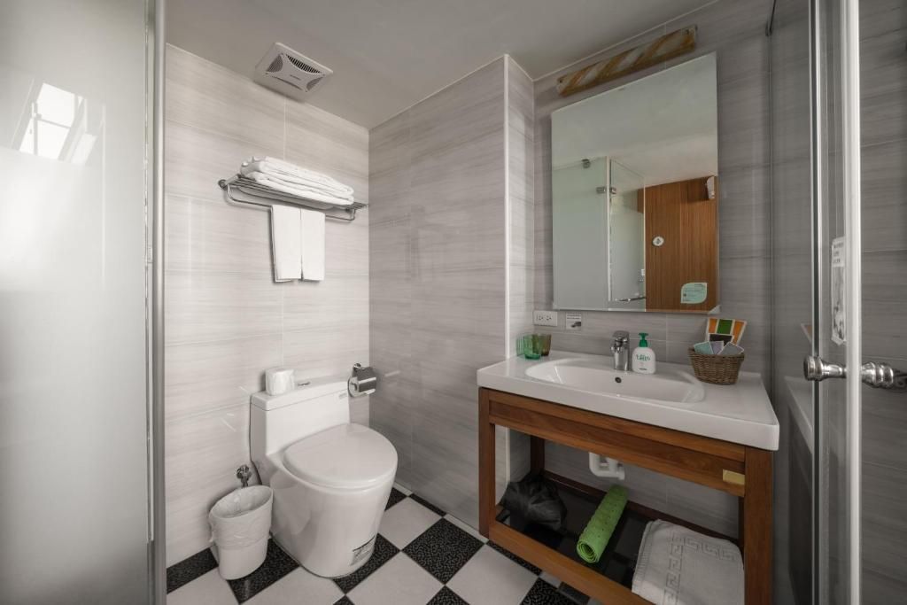 Ein modernes Badezimmer mit Toilette, Waschbecken und Spiegel.