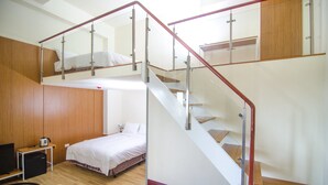 Ein Zimmer mit einem Etagenbett, einem Schreibtisch und einem Stuhl.