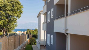 Ein modernes Gebäude mit Balkon, Steinmauer und Meerblick.