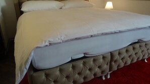 A bed with a tufted headboard and a white mattress. - Harun Apartment (Interlaken)