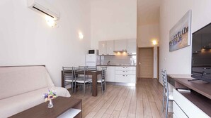 A modern apartment with a living area, dining space, and kitchen. - Holiday apartment with a balcony and sea view (Baška)