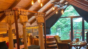 Un dormitorio acogedor en el ático, con una cama, techo de madera y vistas al exterior.