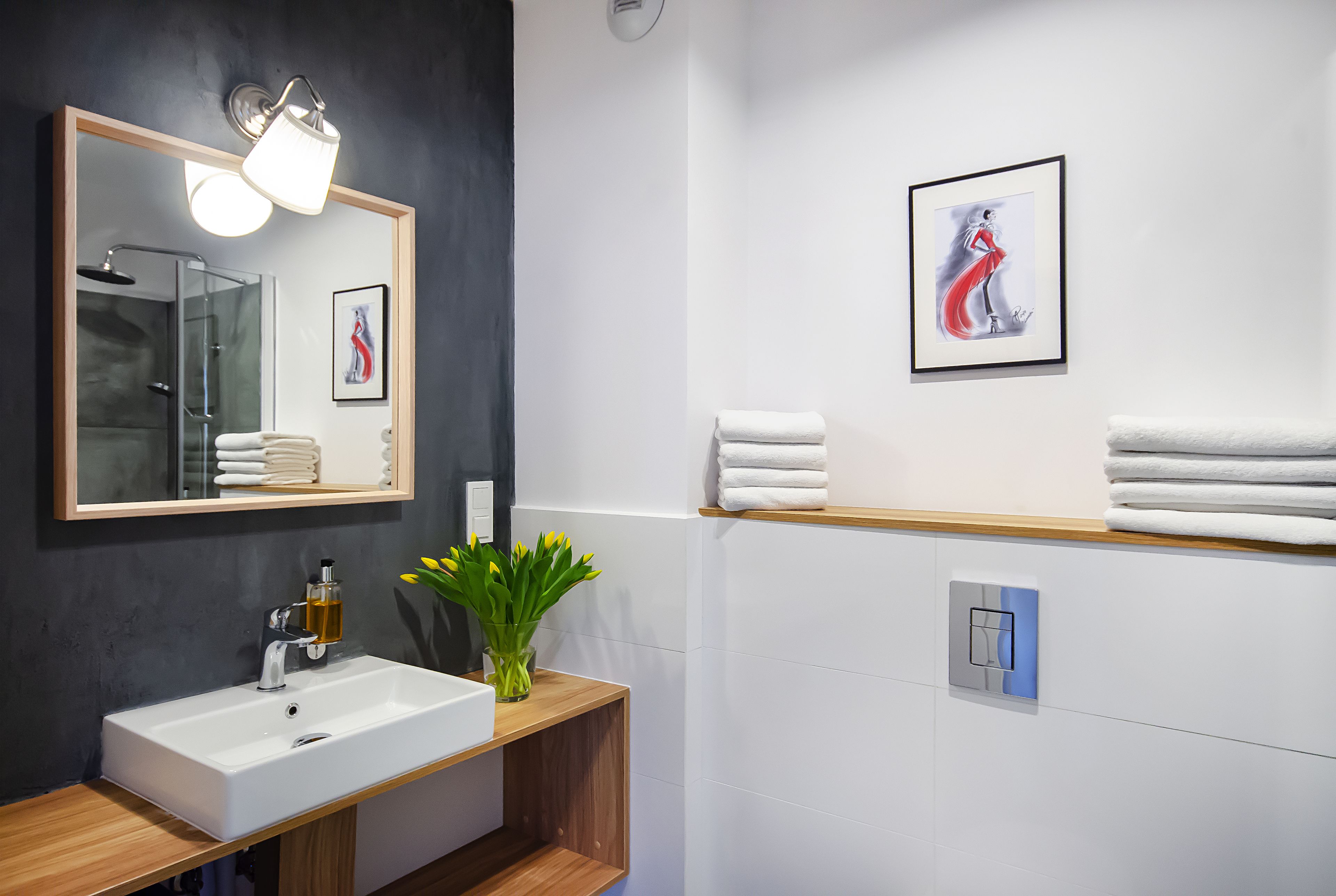 A modern bathroom with a white sink, mirror, and towel rack.