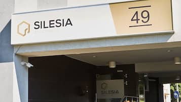 Entrada de un edificio con un cartel que dice "SILESIA APARTMENTS 49".
