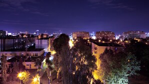Un paisaje urbano nocturno con edificios e iluminados árboles.