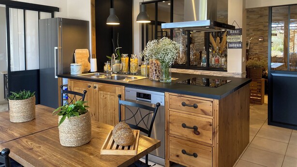 Una cocina moderna con una isla central, electrodomésticos de acero inoxidable y armarios de madera.