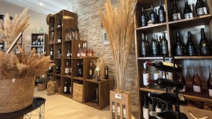 Una tienda de vinos con estantes de madera llenos de diversas botellas y una pared de piedra rústica.