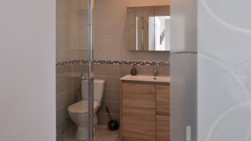 A modern bathroom with a toilet, a sink, and a mirror.