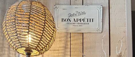 Une étagère en bois rustique, agrémentée d’une lampe décorative, d’une bougie et de fleurs séchées.