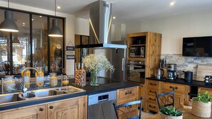 Una cocina moderna con armarios de madera, una estufa de acero inoxidable y un horno empotrado.