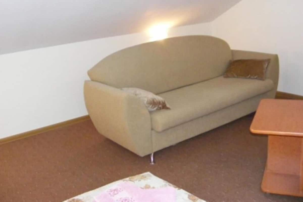 A room with a sofa, a small table, and a skylight.
