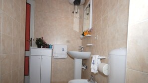 A bathroom with a toilet, sink, and cabinet. - Villa Schiller (Lignano Sabbiadoro)