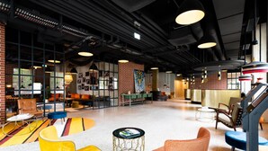 A spacious lobby with modern furniture, a brick accent wall, and a staircase.