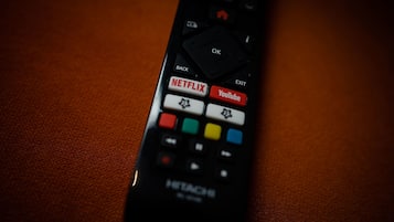 A remote control with buttons labeled "Netflix," "YouTube," and "OK."