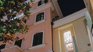 Um edifício com um letreiro de restaurante, uma escadaria e um vaso de planta.
