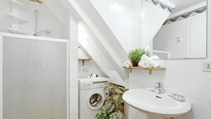 A modern bathroom with a washing machine, a sink, and a mirror. - Grimaldi Apartments - Lionello (Venice)