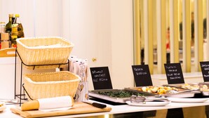 A buffet setup with various food items and baskets. - Hotel Universal (Cattolica)
