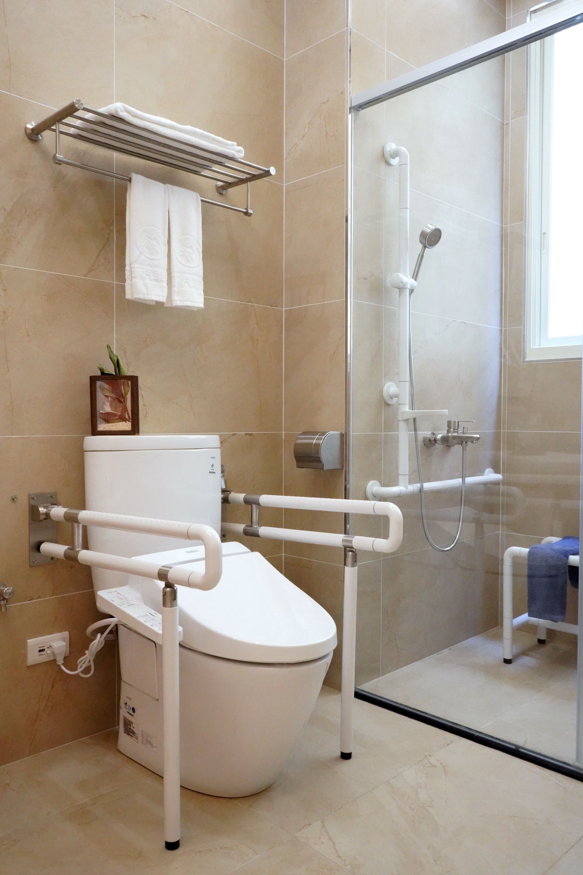 A modern bathroom with a toilet, a shower, and a glass-enclosed shower area.