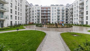 A modern apartment complex with multiple floors, balconies, and a central courtyard with a playground. - Dream Holiday Apartament (Gdansk)